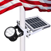 Aurolit Auro 7 flagpole light glowing at dusk for enhanced flag visibility.
