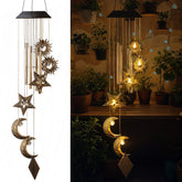 Colingmill Sun Moon Star wind chimes glow at night over a cozy patio space.