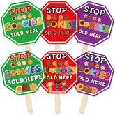 ComfyKit red cookies sold here sign on a wooden stake boosts booth visibility.