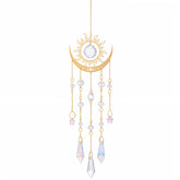 Divina Vitae crystal suncatcher on a window casting vivid rainbow colors for ambience.