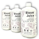 Elm Dirt Bloom Juice bottle on a potting bench boosts flowering plants with organic nutrients.