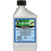 Ferti-lome Tree and Shrub Drench bottle pouring around base for root uptake.