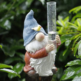 FORUP resin gnome rain gauge in a garden with clear inches and centimeters readings.