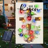 Gosuoa He Is Risen Easter flag with solar LEDs lighting the yard at dusk.