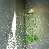 HDCRYSTALGIFTS green crystal suncatcher glows with rainbow light in a window