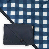 Little Unicorn 5x7 blanket folded in navy plaid, easy to pack for outings.