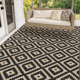 Mattitude 5x8 outdoor rug on patio, black and beige, weather-ready.