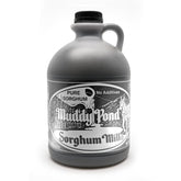 Muddy Pond Sorghum bottle close-up reveals rich amber color, ideal for natural sweetness on pancakes.