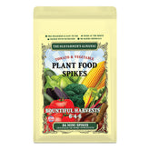 Old Farmer's Almanac tomato and vegetable mini spikes pressed into soil for root-zone nutrition.