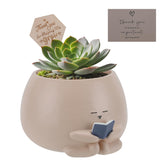 Onzbala Bookworm Planter Pot with card and sign enhances a cozy reading corner.