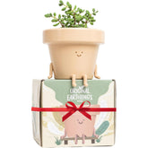 Original Earthlings sitting small plant pot with cheerful design for windowsill decor.