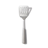 OXO Steel Cooking Turner head close-up showing sturdy flexibility for easy flipping.