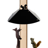RELIY metal squirrel baffle on a 4x4 post protecting bird feeders from intruding squirrels.