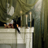 RunNico green Halloween cheesecloth draped on a stairway to create eerie ambiance