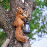 SHAODIE Squirrel lantern-holding sculpture adds warm dusk lighting to gardens.
