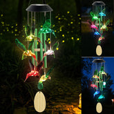 Six Foxes hummingbird solar wind chime glows with colorful light for outdoor decor.