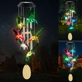 Six Foxes solar hummingbird wind chime glowing colors at night for outdoor charm.