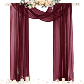 Socomi burgundy sheer panel drape on a wedding arch creates a soft, romantic backdrop.