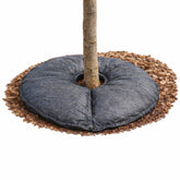 SteadySpring tree mat installation around a root ball for steady moisture delivery.