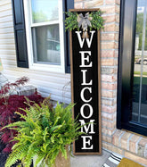 Surfapans welcome sign on front porch wood black enhances rustic curb appeal.