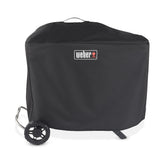Weber Traveler Premium Cover weatherproofs the upright grill against rain and sun.