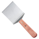 Winco TN46 rigid blade turner on a hot griddle for steaks and burgers.