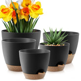 YNNICO 10-inch black self-watering plant pot shown with lush greenery for indoor use.