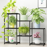 YUJCHMTZN three-tier metal plant stand displaying multiple pots in a living room.