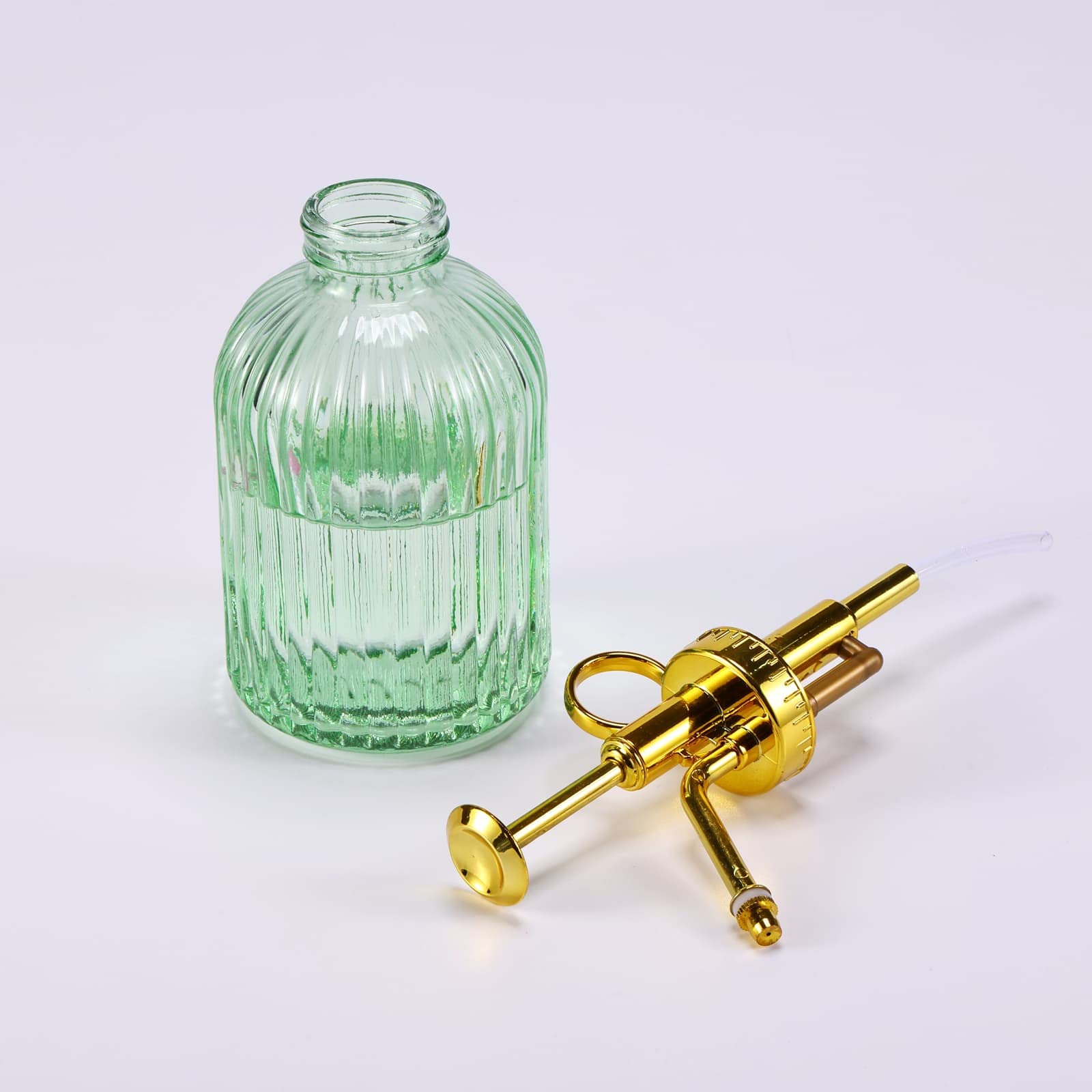Aebor green glass container ready for misting outdoor potted plants.