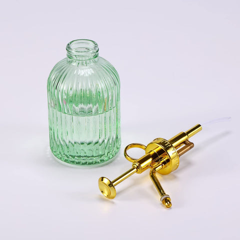 Aebor green glass container ready for misting outdoor potted plants.