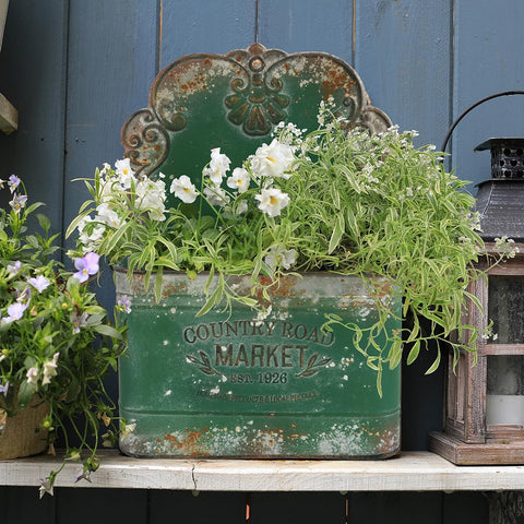 All Chic metal wall planter filled with flowers enhances curb appeal