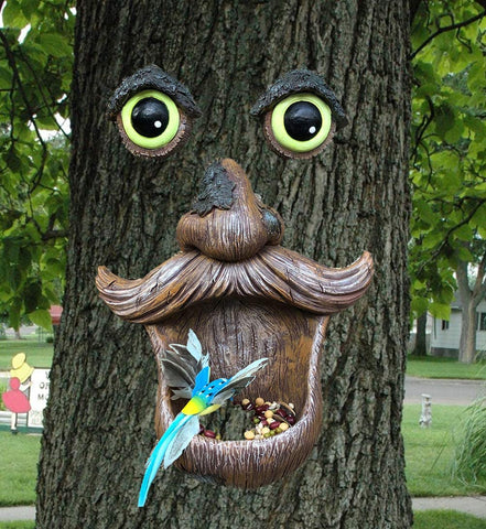 ALLADINBOX Tree Face Birdfeeder serves as charming yard art and wildlife attractor.