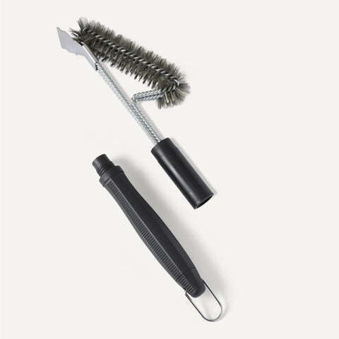 Amazon Basics grill brush with steam-clean capability demonstrated on hot grates.