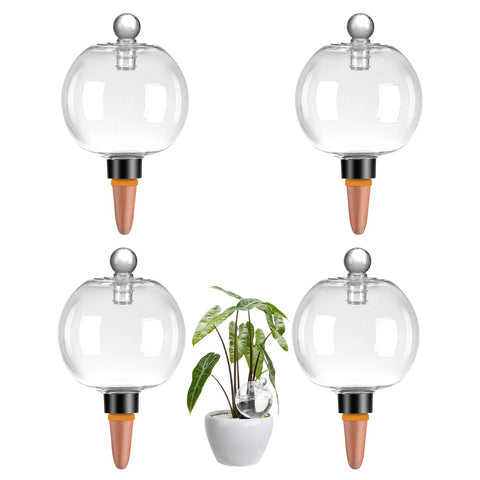 Ansberta 4-pack watering globes with covers in a potted plant, keeping soil evenly moist.