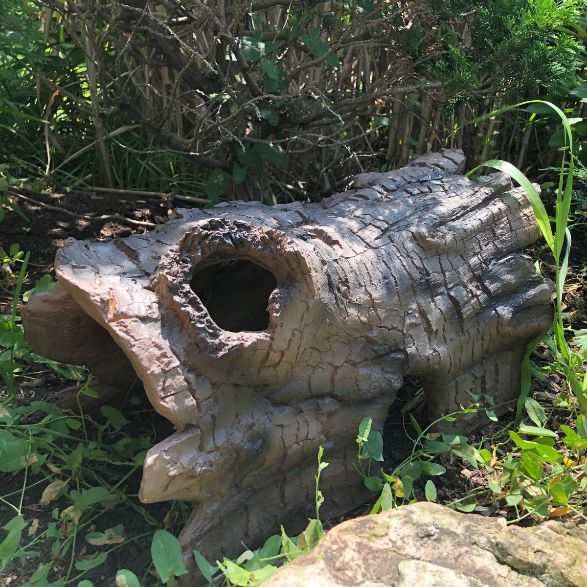 Aquascape faux log fish cave creates a decorative focal point in water garden.