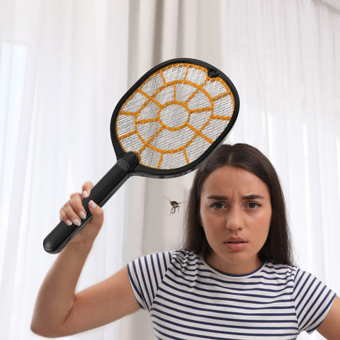 BLACK+DECKER Bug Zapper Racket at a barbecue deterring mosquitoes.