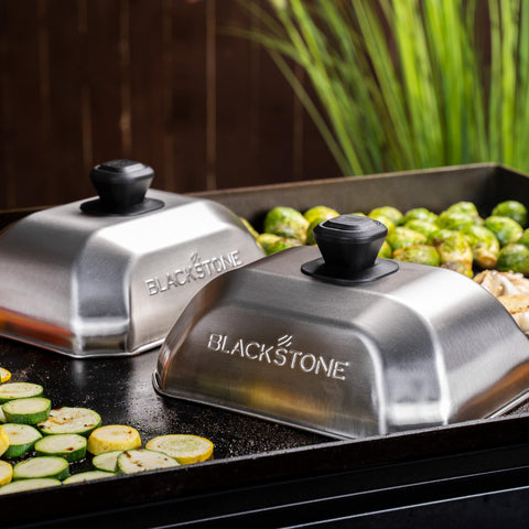 Blackstone basting cover griddle accessory keeps splatters contained while cooking burgers.
