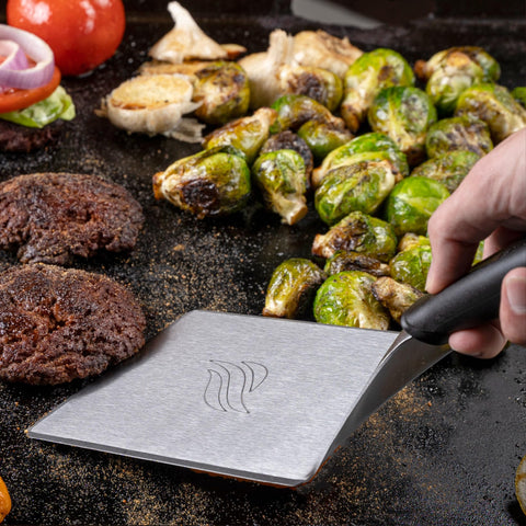 Blackstone spatula flipping pancakes on a hot griddle with precision.