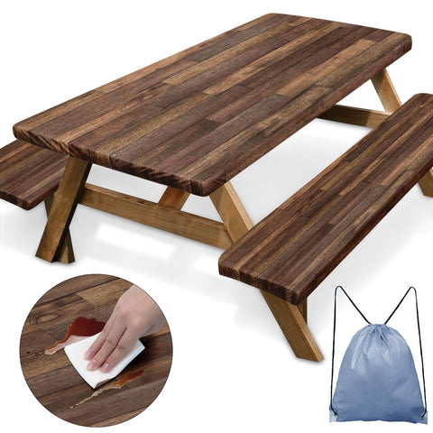 Britown picnic table cover with elastic edges on brown wood beside a campsite