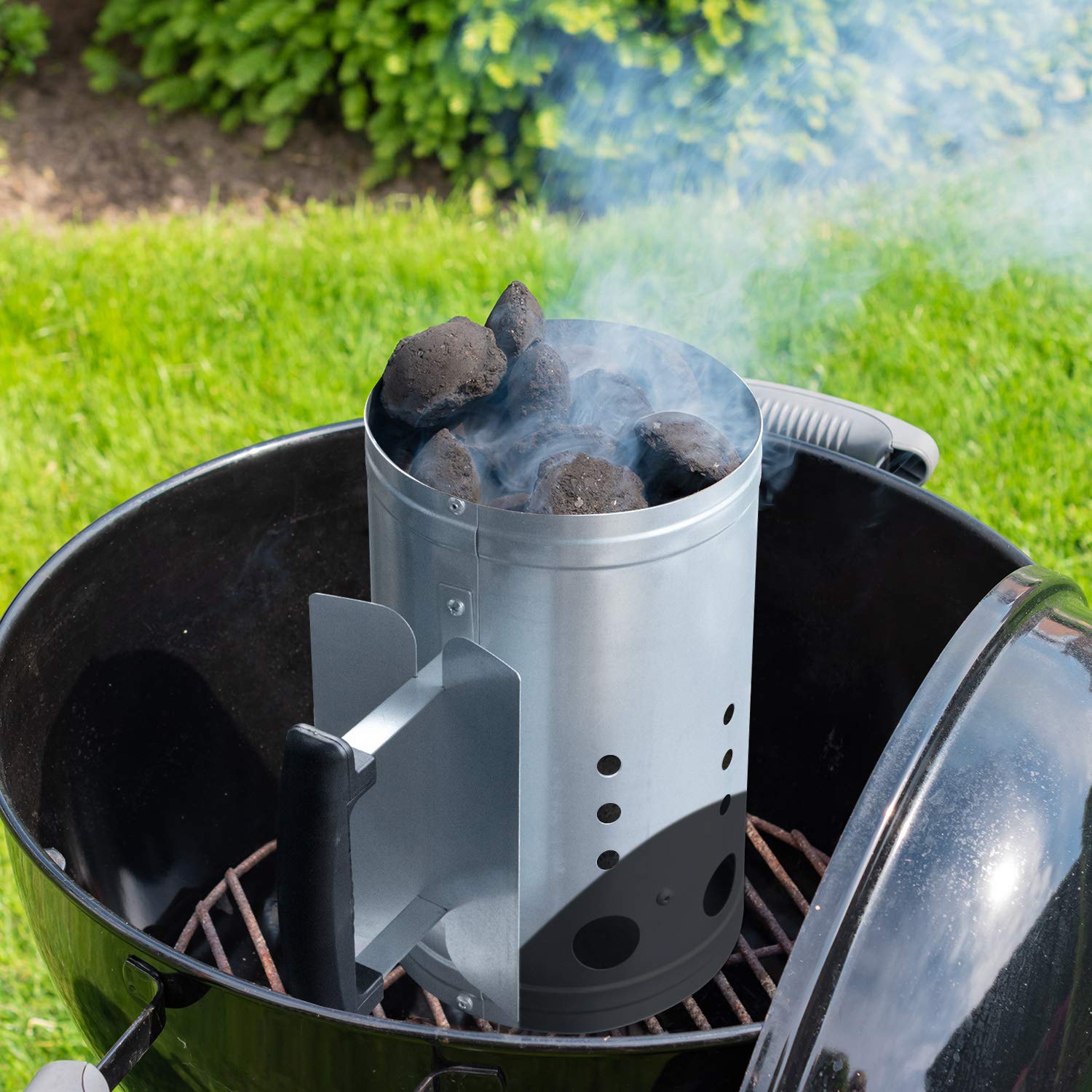 CADARA charcoal chimney starter beside grill in outdoor cooking setup.