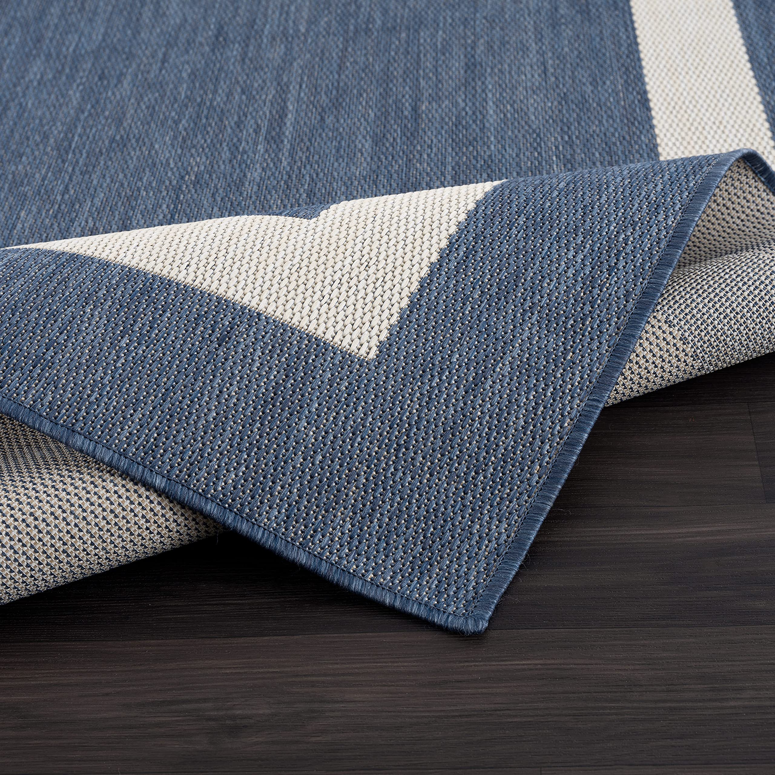 CAMILSON outdoor rug on a sunlit patio with blue-white border design.