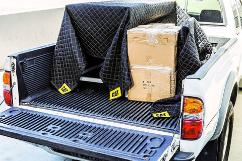CAT Utility Padded Moving Blanket protecting a TV and sofa during transit.