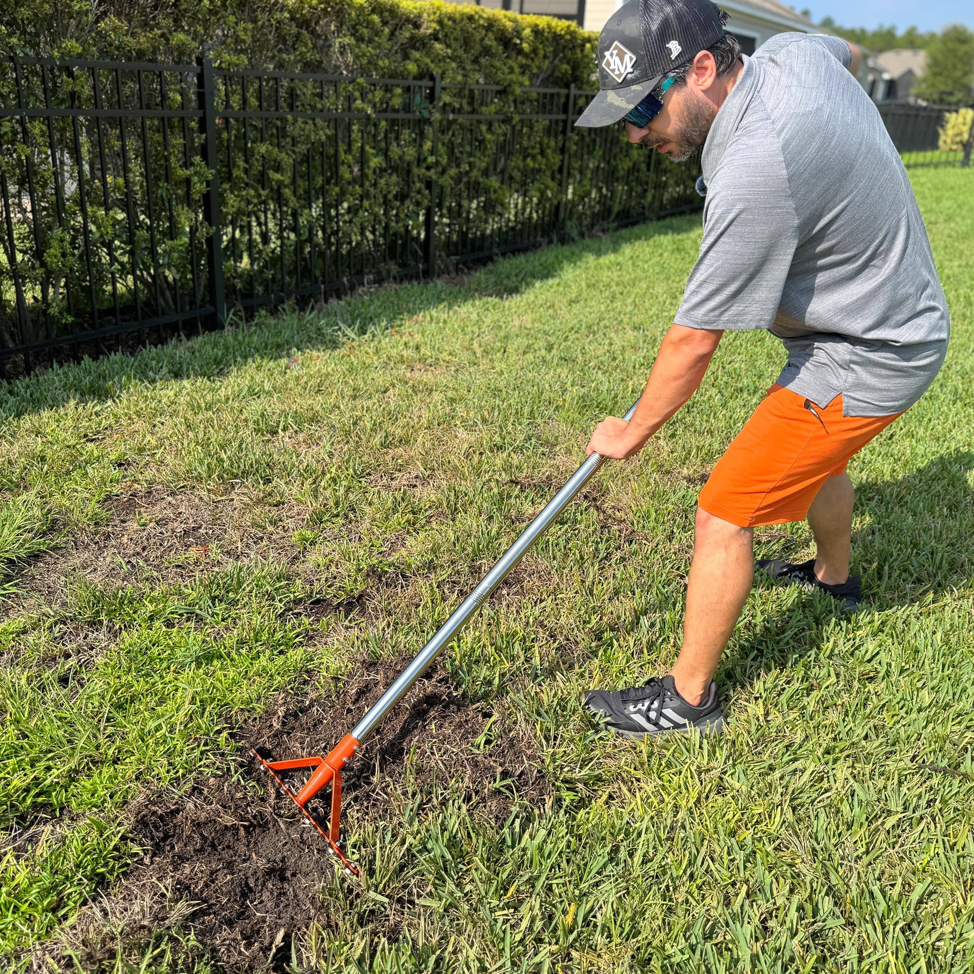 CKLT garden rake in use on a lawn clearing debris.