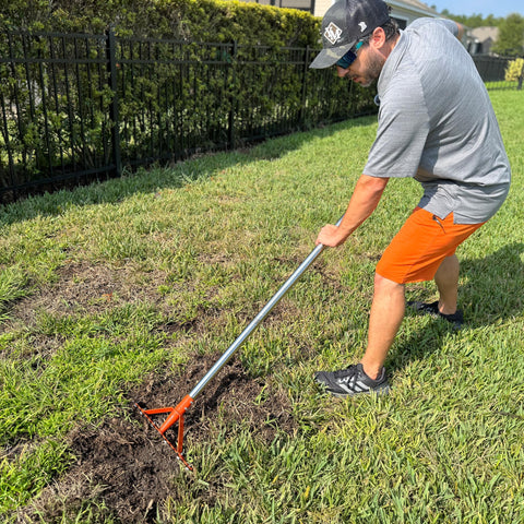 CKLT garden rake in use on a lawn clearing debris.