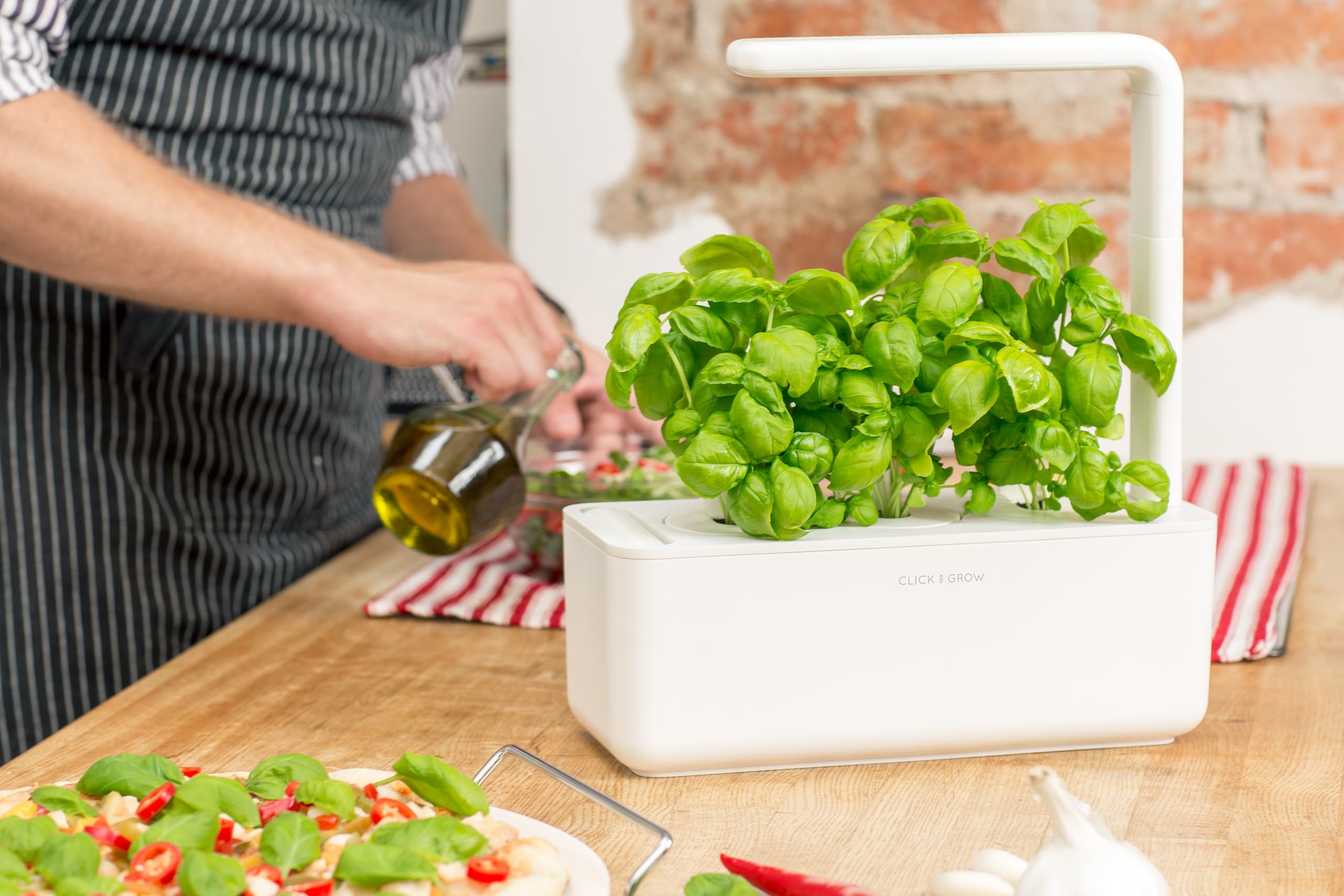Click & Grow grow-light illuminates leafy herbs for year-round harvests.
