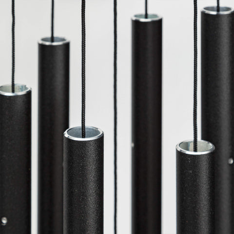 Corinthian Bells 27in black chime tubes closeup, highlighting pentatonic tuning for outdoor tones.