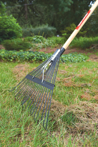 Craftsman lawn rake in use with cushioned grip for comfortable raking.