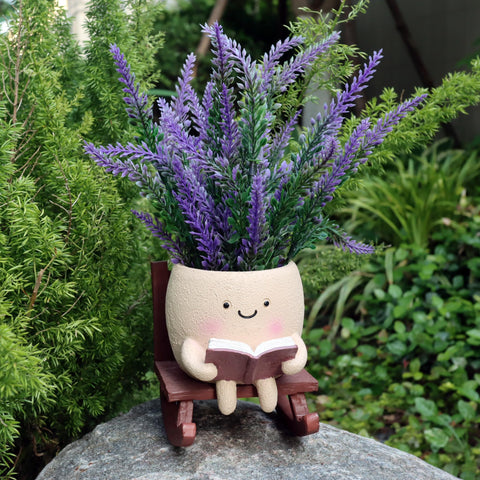Dolkgy reading-head planter with succulent adds whimsical shelf charm.