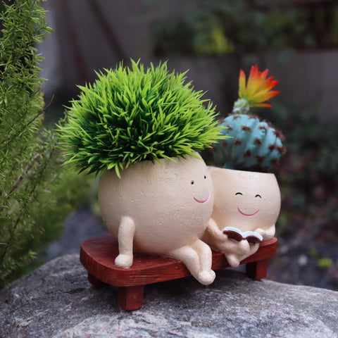 Dolkgy head vase with mother-daughter reading design adds whimsy to decor.