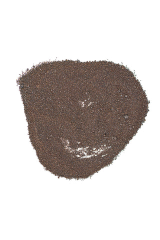 Earth Science Blood Meal in a lush garden bed supporting shrubs and vegetables.